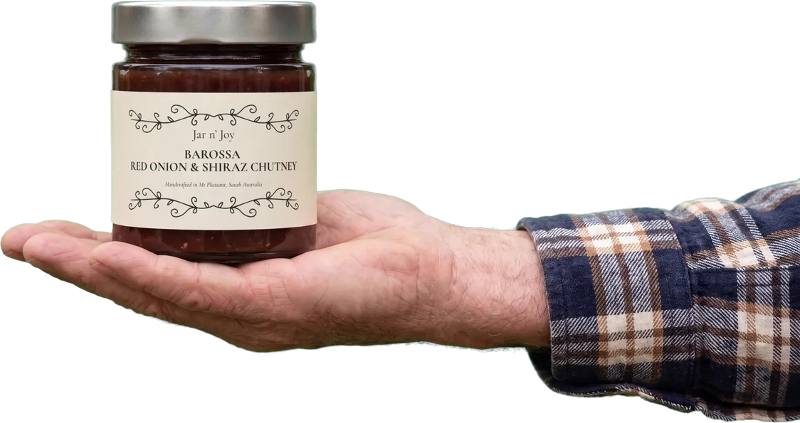 A jar of Jar n’ Joy Barossa Red Onion & Shiraz Chutney held in an open hand